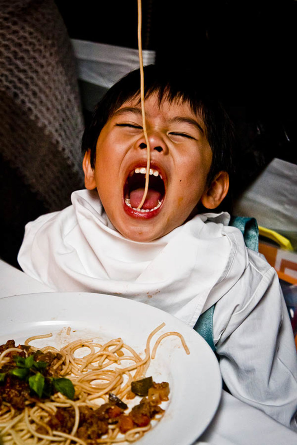 Boy eating spaghetti at wedding reception