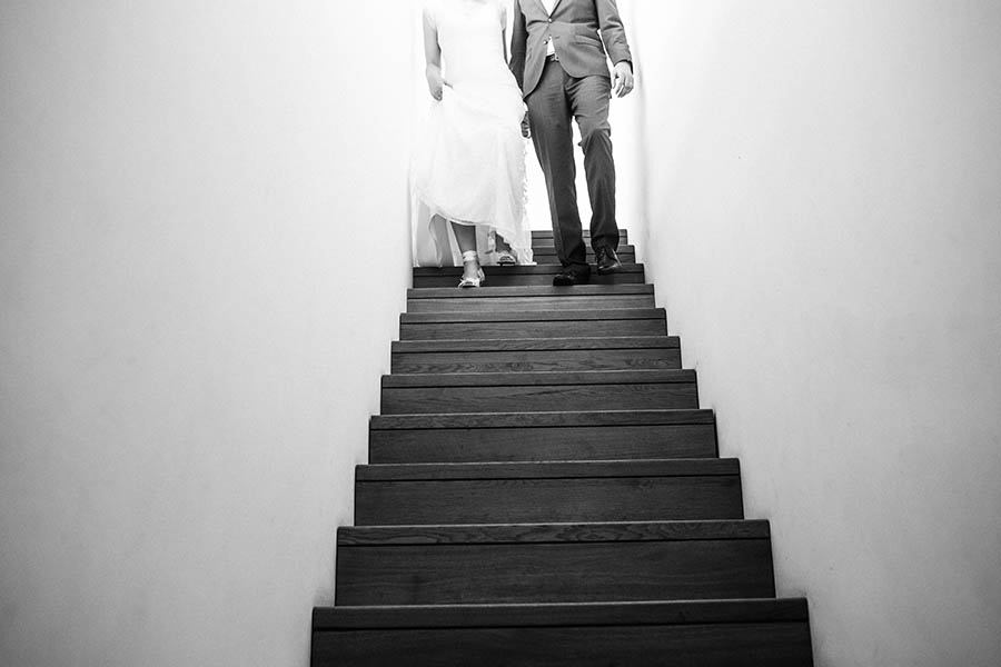 bride and groom walk down staircase