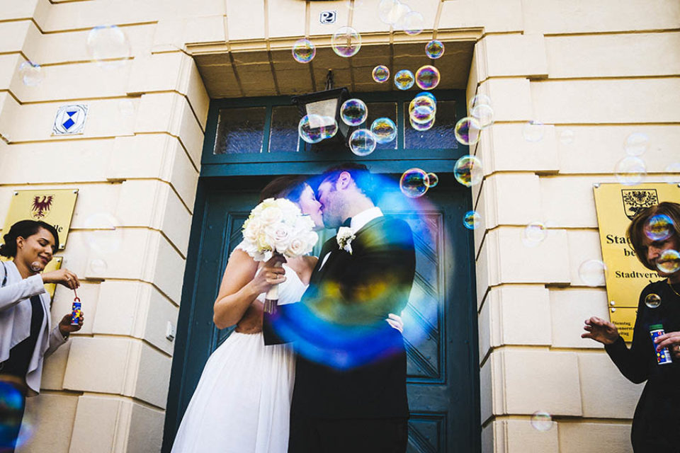 Newlyweds kissing through soap bubble