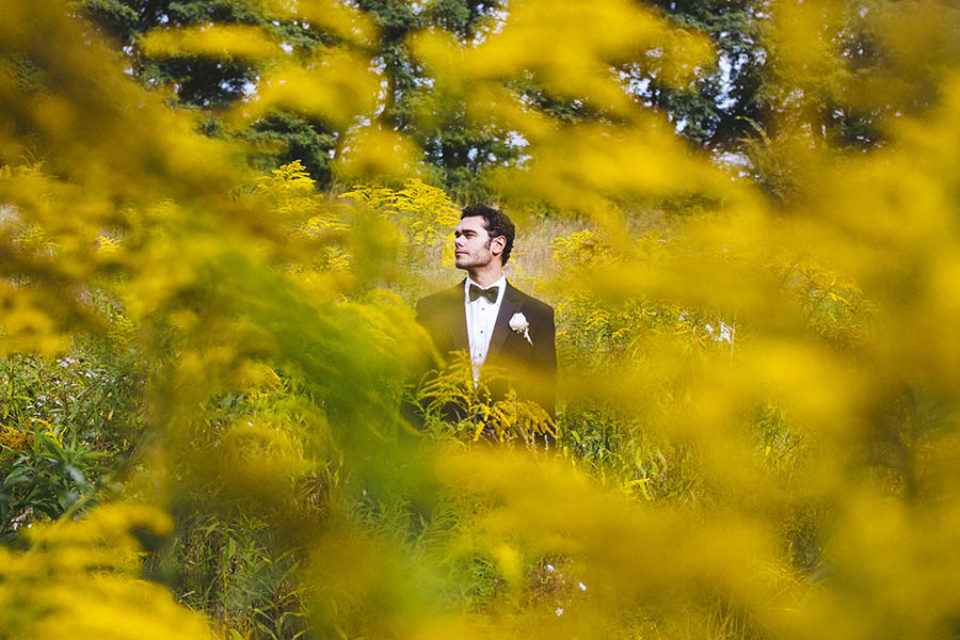 Groom photographed through yellow flowers