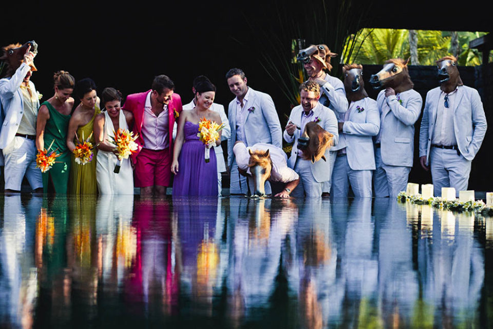 A quirky wedding party joking by pool
