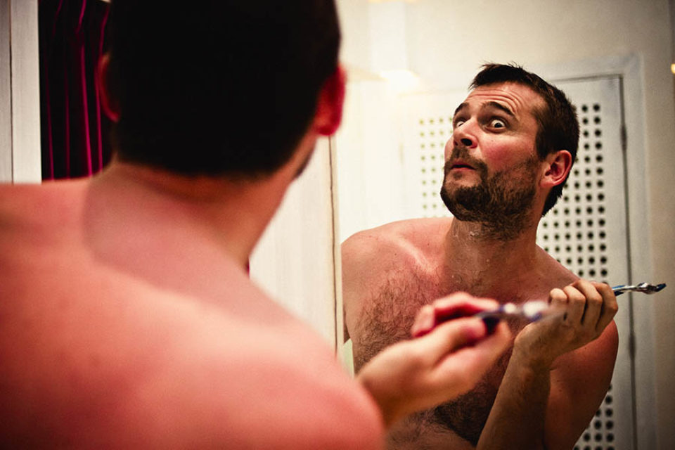 Groom making a funny face in mirror