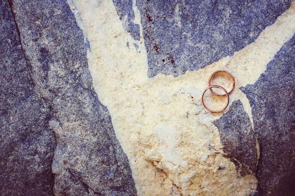 Wedding rings lay on stone