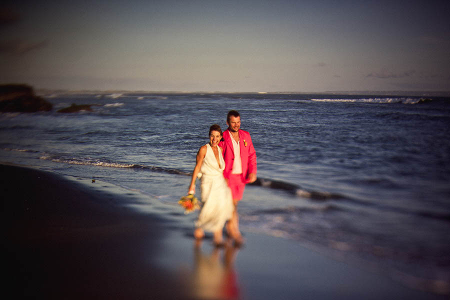 Newlyweds walking along beach