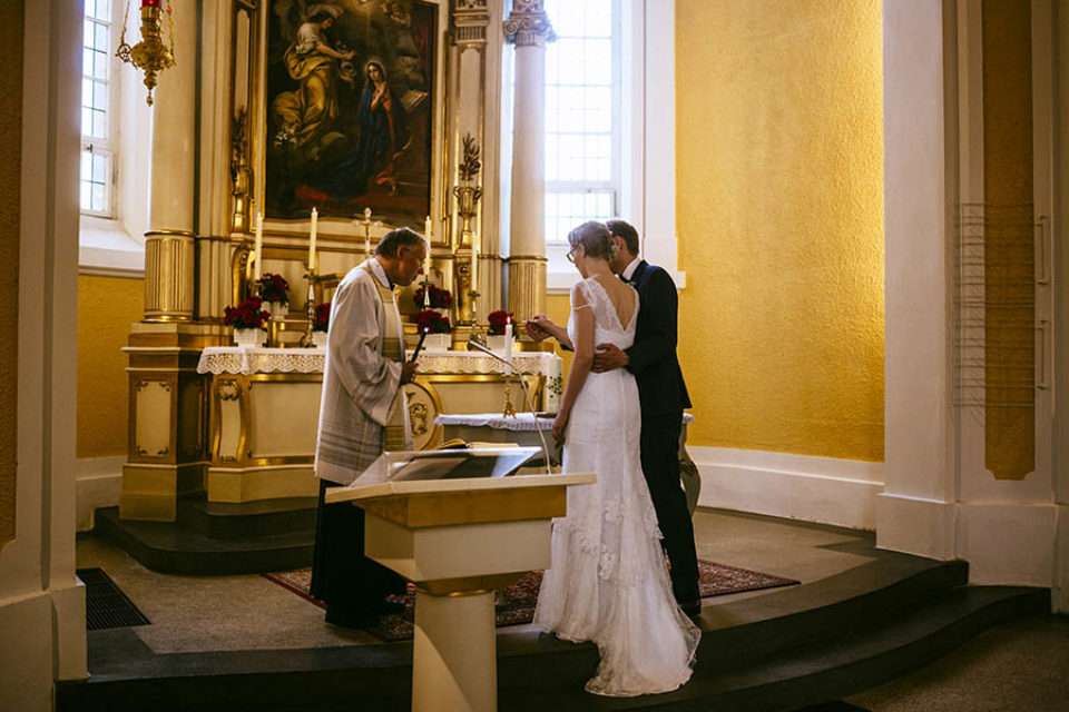 Newlyweds lighting candle in church