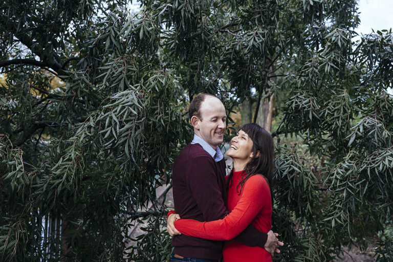 Couple laughing among leaves