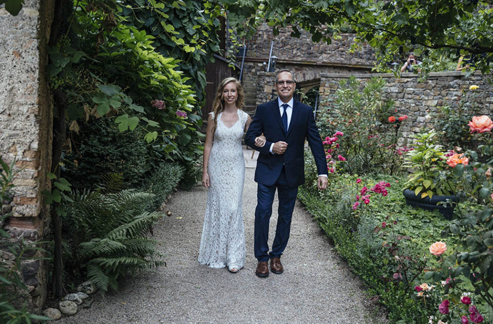 Father walks bride up aisle, castle garden