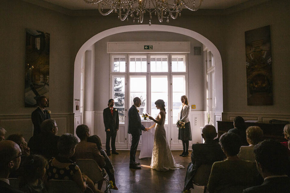 Bride reading vows to groom by window