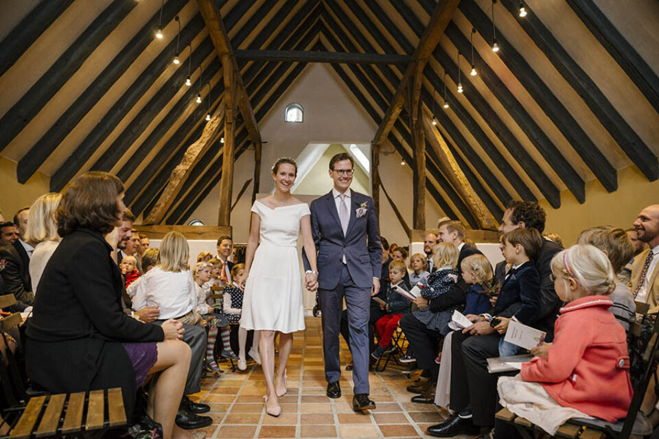 Bride and groom walk down chapel aisle