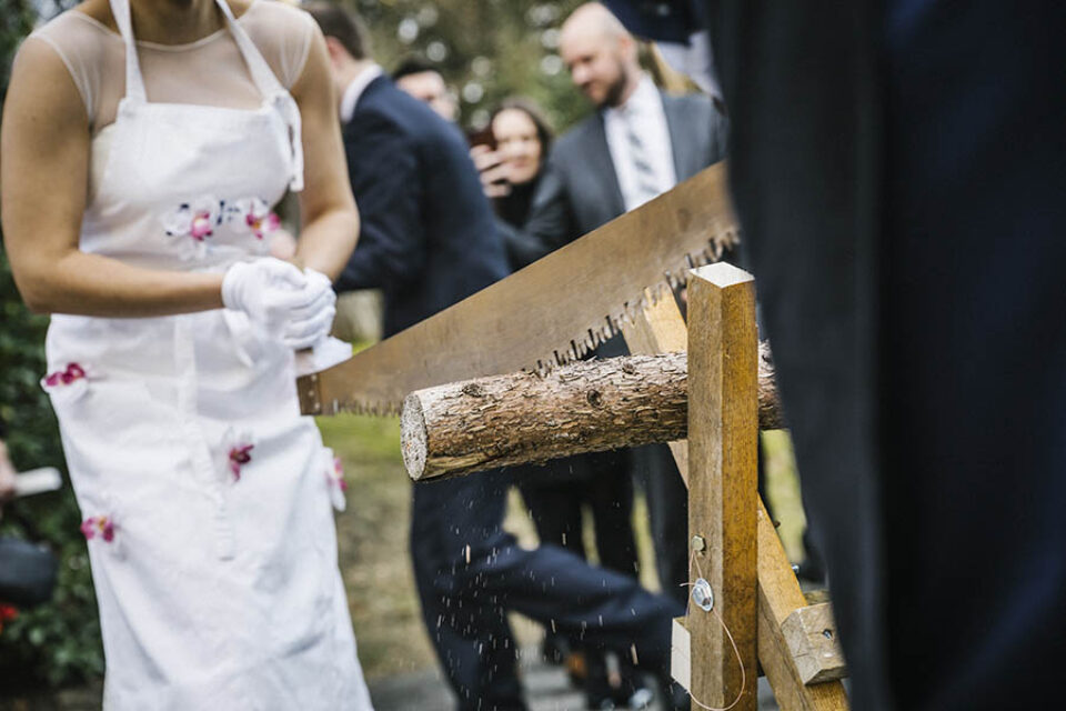 Bride and groom saw through log