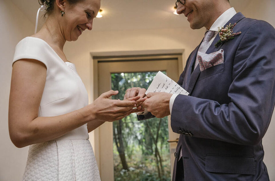 Groom giving bride wedding ring