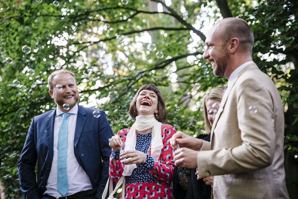 Wedding guests laugh outside chapel