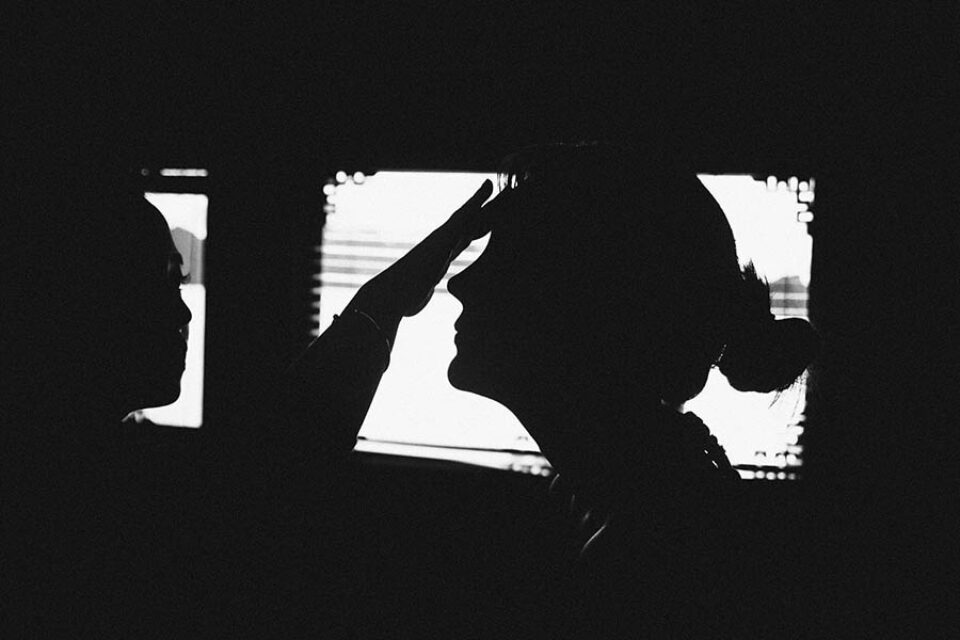 Silhouetted bride having makeup applied