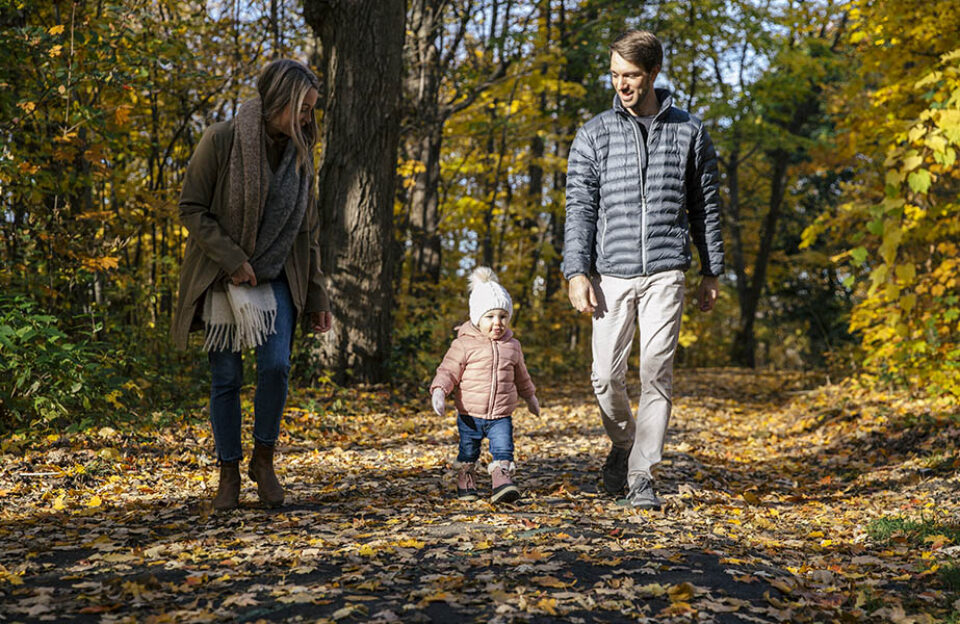 Family walking in fallen leaves