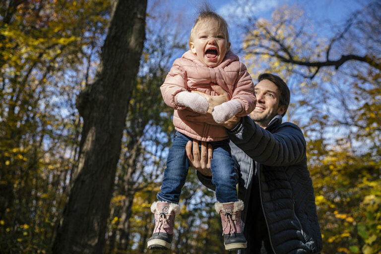 Father playing with child in the Fall