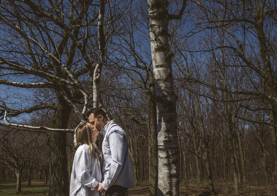 Couple kissing among the trees